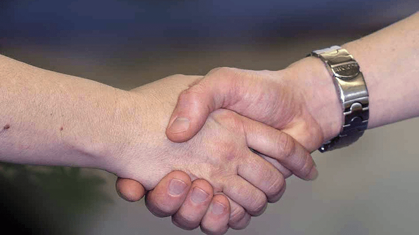 Två händer som tar varandra i hand.