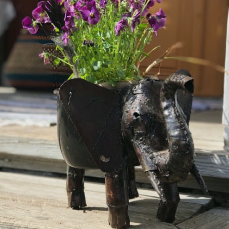 Kruka föreställande en elefant med blommor i.
