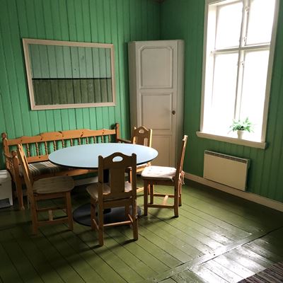 Sittplatsen i ett grönt inrett kök med ett runt bort, limegrönt golv och knalligt grönt på väggarna.