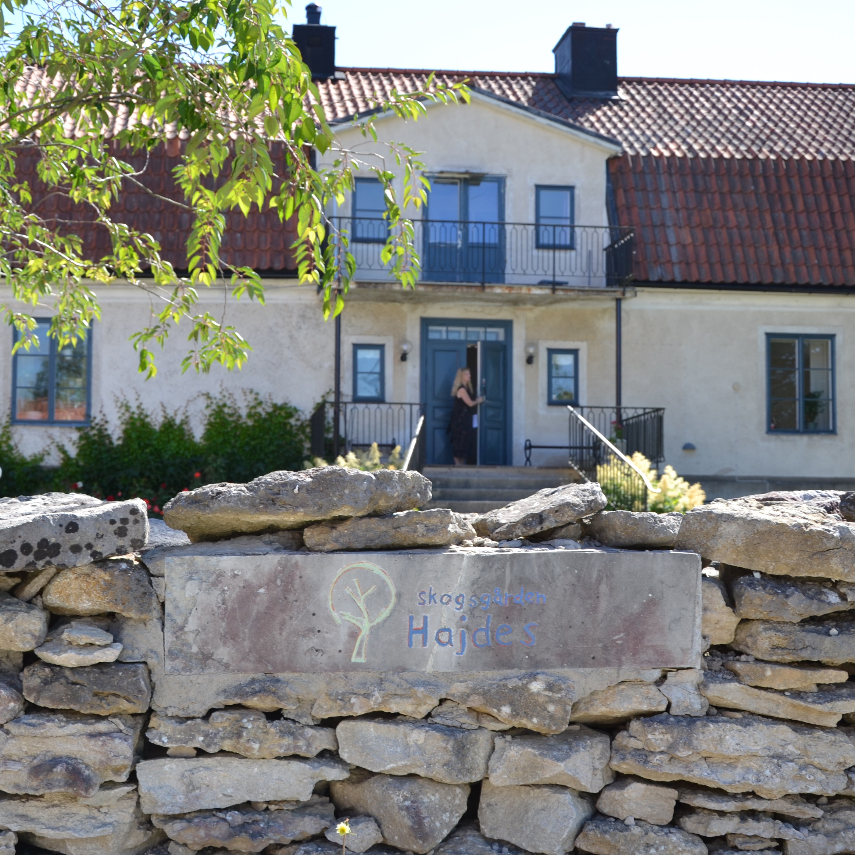 Hajdes och den vita byggnanden. I förgrunden ser man en vitgrå charmig  stenmur.