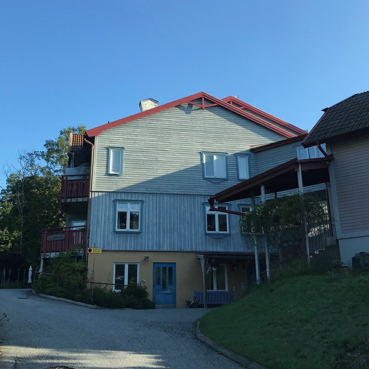Ett grönt hus hos LRG Fastigheter med grön och skön gräsmatta utanför.