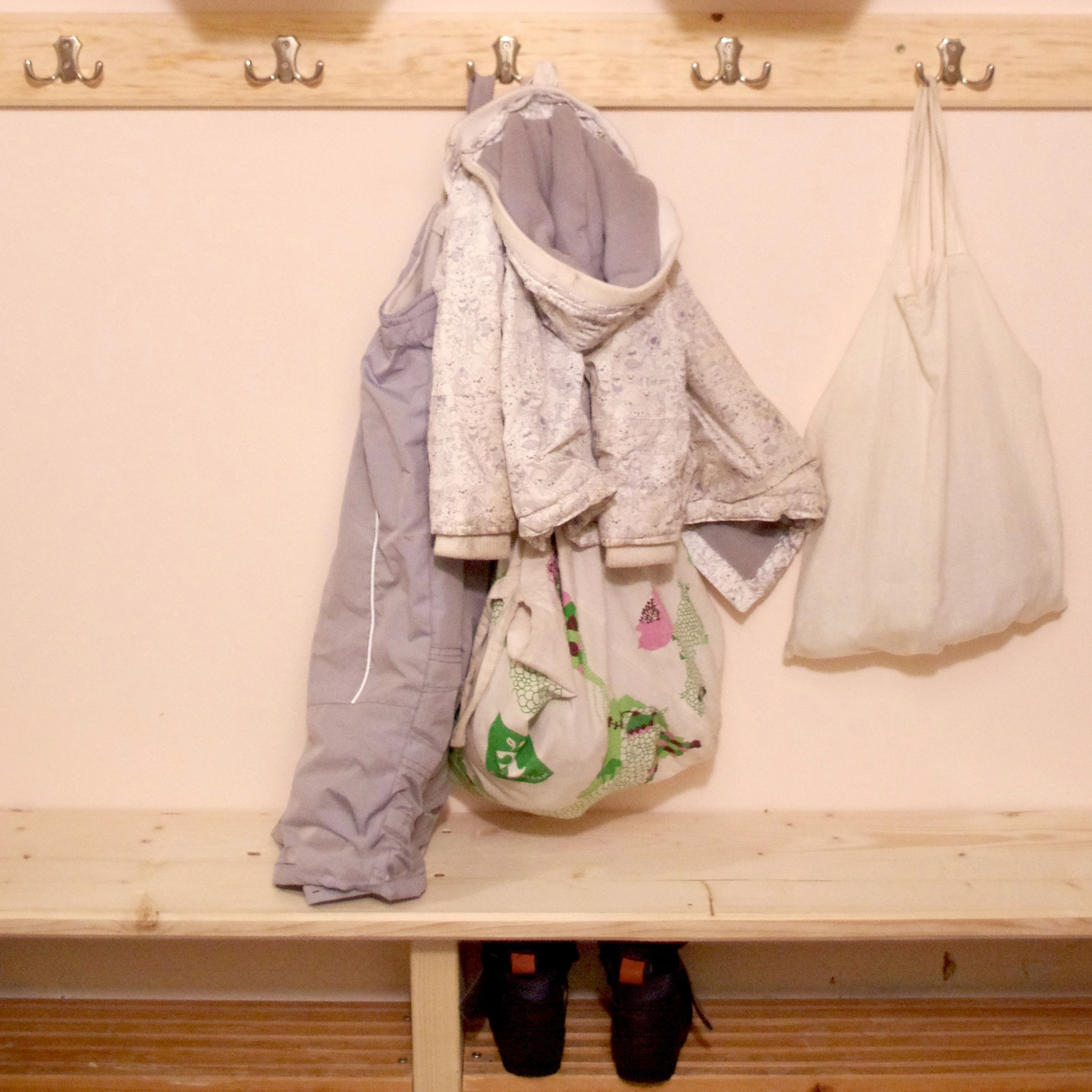 Här hänger ytterkläder och annat på krokarna på väggen.