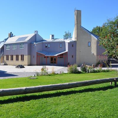 Ett ljust hus och i förgrunden finns en gräsmatta.