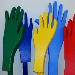 Fem olikfärgade trähänder som sträcker sig uppåt.