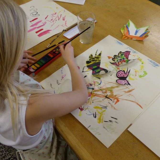 Uppsala waldorf: i ett klassrum sitter ett barn och ritar och färglägger i en bok.